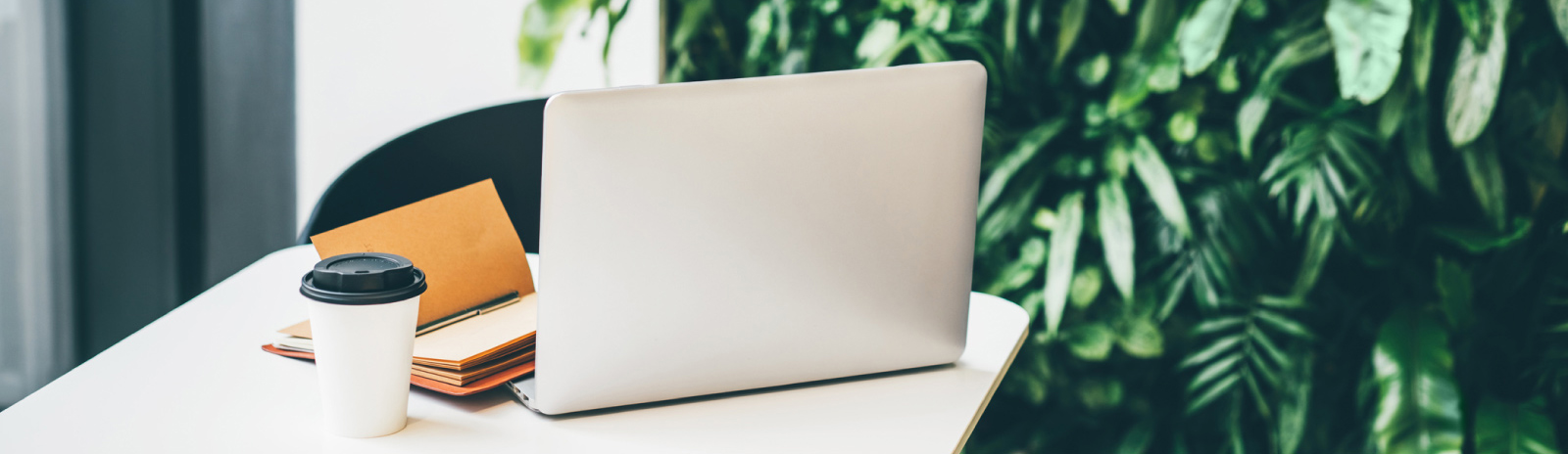 a laptop computer next to a cup of coffee