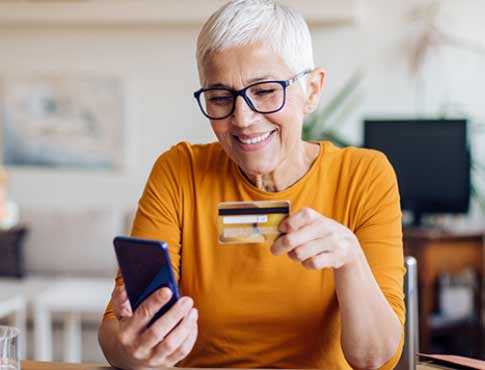 mature woman holding a credit/debit card