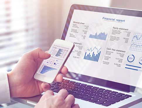 a person checking a financial report on their cell phone and laptop